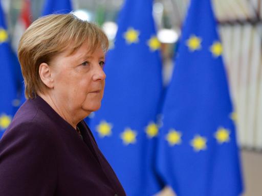 Bundeskanzlerin Merkel steht vor mehreren EU-Flaggen.