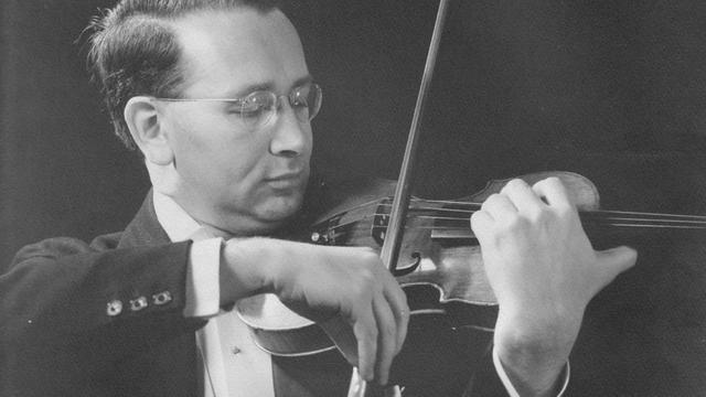 Schwarzweiß-Aufnahme: Mann in Frack spielt Geige