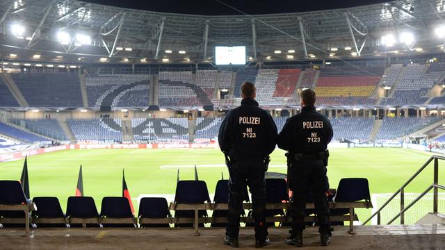 Zwei Polizisten stehen auf der Tribüne des Fußballstadions in Hannover.