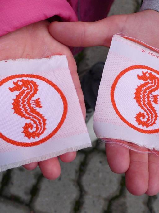 Kinder halten das Seepferdchen-Schwimmabzeichen in den Händen.