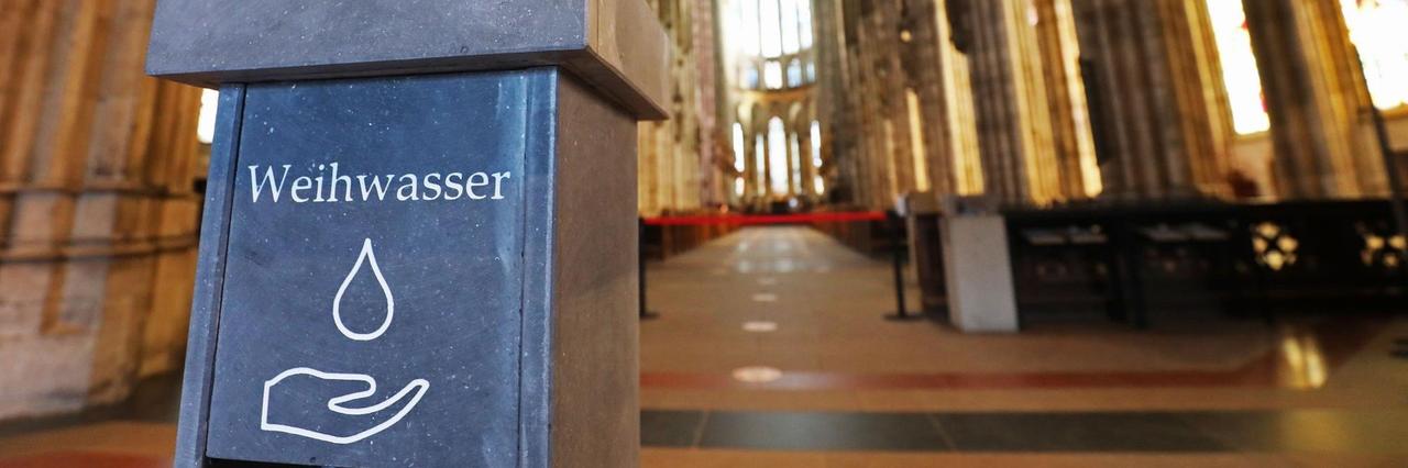 Nordrhein-Westfalen, Köln: Ein kontaktloser Weihwasserspender steht für die Gläubigen im Dom am Eingang bereit. Nordrhein-Westfalen, Köln: Ein kontaktloser Weihwasserspender steht für die Gläubigen im Dom am Eingang bereit.