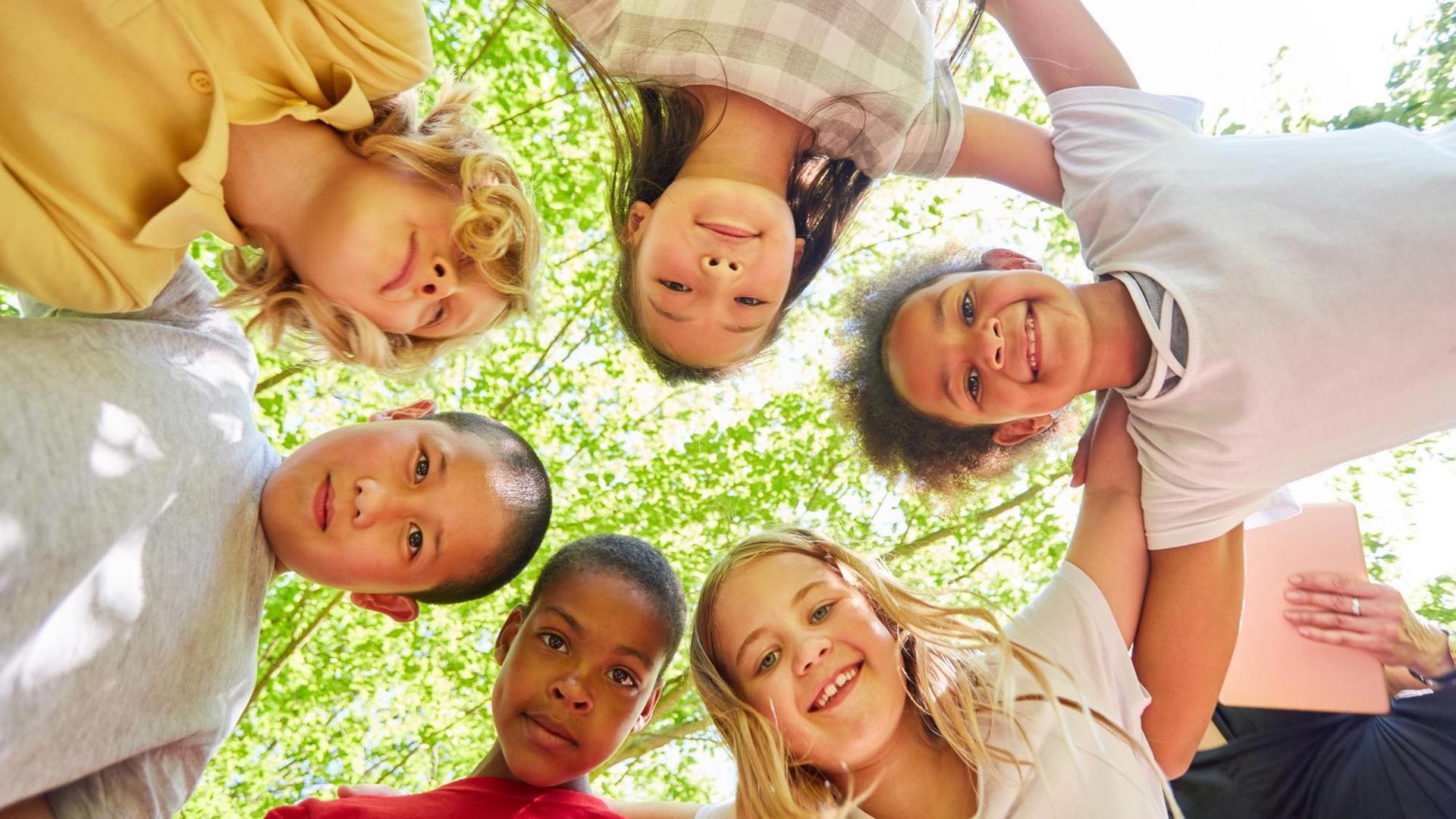 Gruppe Kinder als multikulturelles Team im Kreis Gruppe Kinder als multikulturelles Team im Kreis