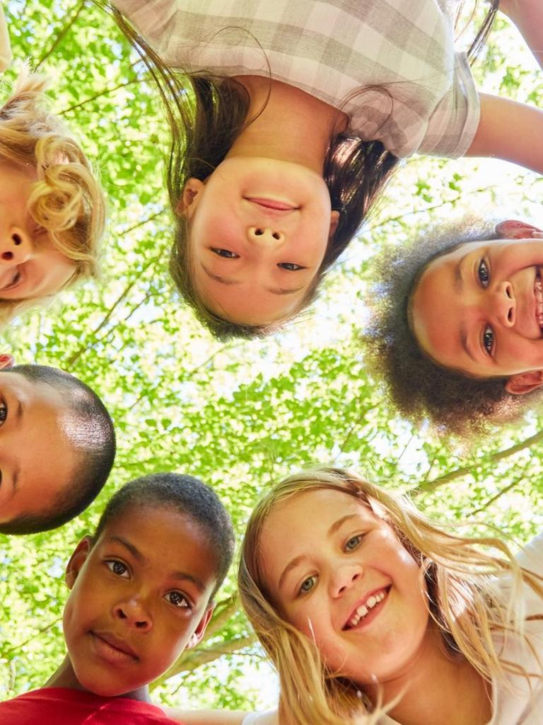 Gruppe Kinder als multikulturelles Team im Kreis