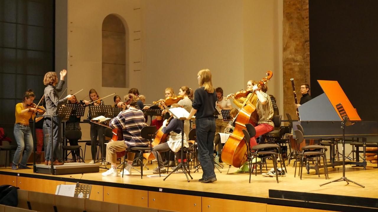 Orchester probt mit Solistin und Dirigenten auf der Bühne. Orchester probt mit Solistin und Dirigenten auf der Bühne.