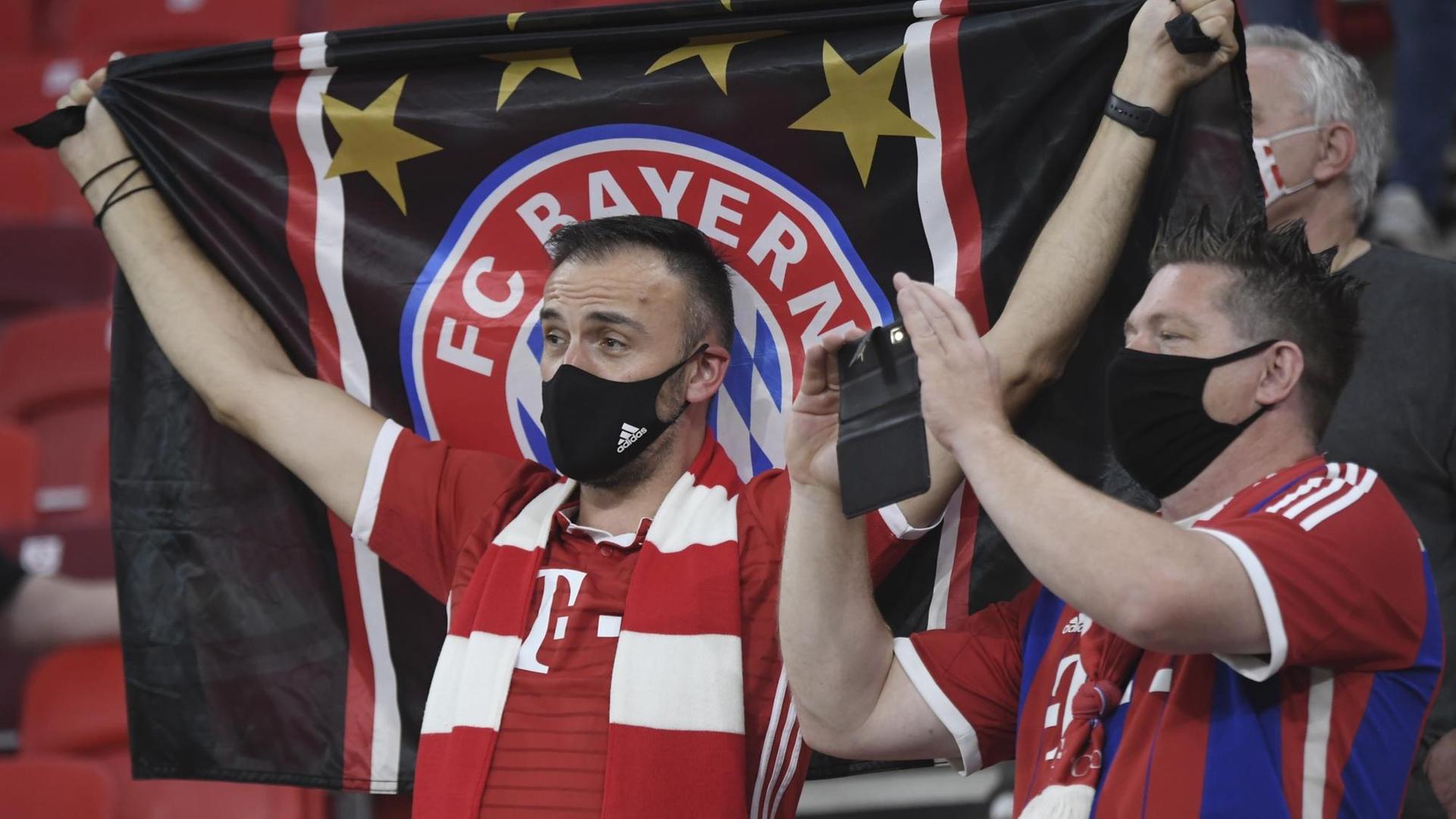 Fans von Bayern München stehen auf der Tribüne. Fans von Bayern München stehen auf der Tribüne.