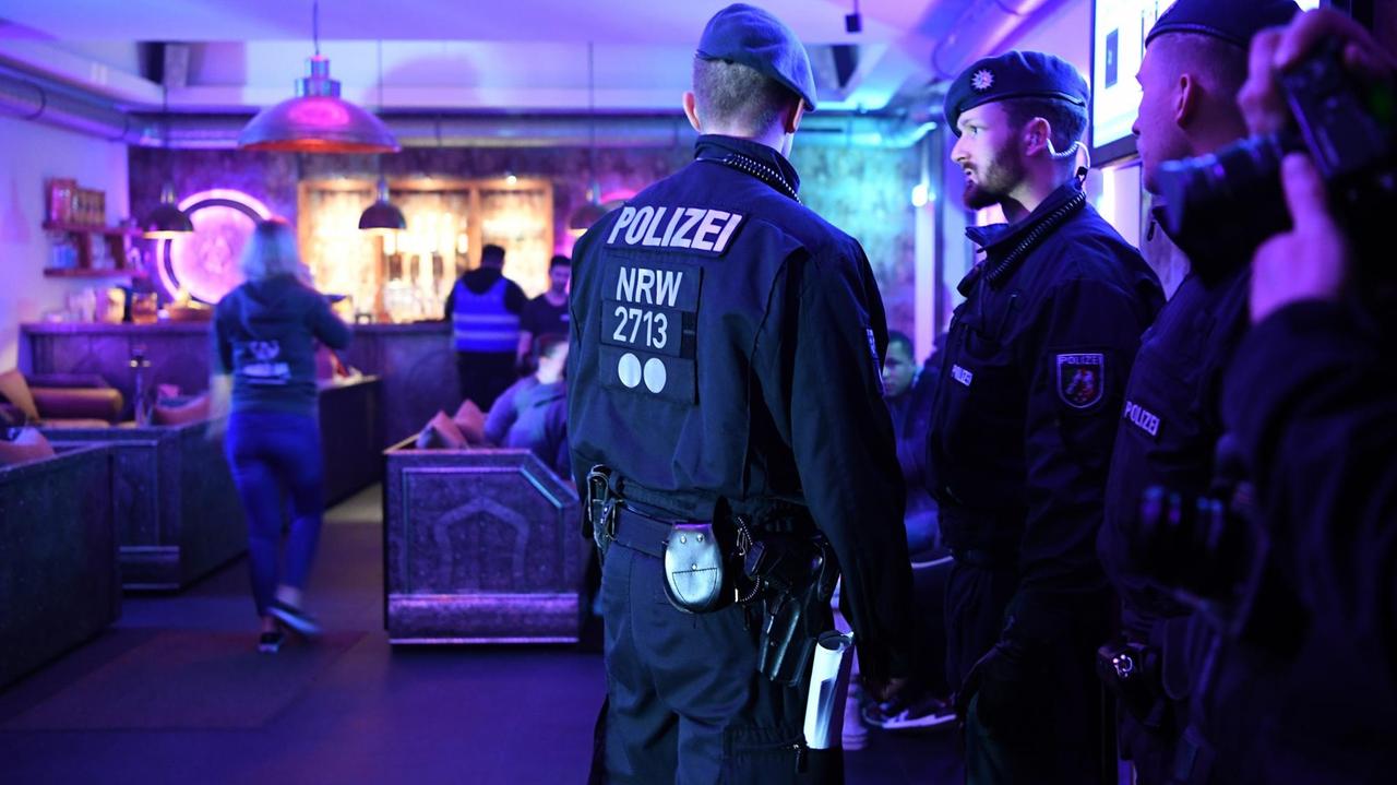 12.04.2018, Nordrhein-Westfalen, Essen: Polizisten stehen in einem Lokal. In der nördlichen Innenstadt gab es eine Razzia in verschiedenen Lokalen, die von der Polizei als Kriminalitätsschwerpunkt bezeichnet werden. Foto: Ina Fassbender/dpa | Verwendung weltweit 12.04.2018, Nordrhein-Westfalen, Essen: Polizisten stehen in einem Lokal. In der nördlichen Innenstadt gab es eine Razzia in verschiedenen Lokalen, die von der Polizei als Kriminalitätsschwerpunkt bezeichnet werden. Foto: Ina Fassbender/dpa | Verwendung weltweit