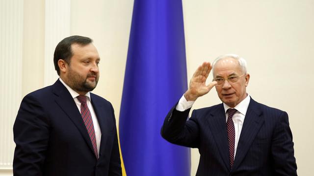 Der frühere ukrainische Premierminister Nikolai Asarow (r.) übergibt nach seinem am Vortag angekündigten Rücktritt am 29.1.2014 die Regierungsgeschäfte kommissarisch an Sergej Arbusow (l.)