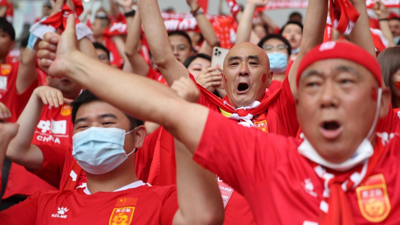 Chinesische Fußballfans jubeln im Stadion Chinesische Fußballfans jubeln im Stadion