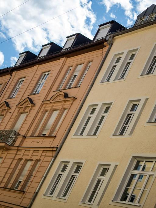 Verschiedenfarbige Wohnhäuser im Stadtteil "Altstadt Lehel" in München vor dem blauen Himmel mit leichten Wolken, aufgenommen 2015