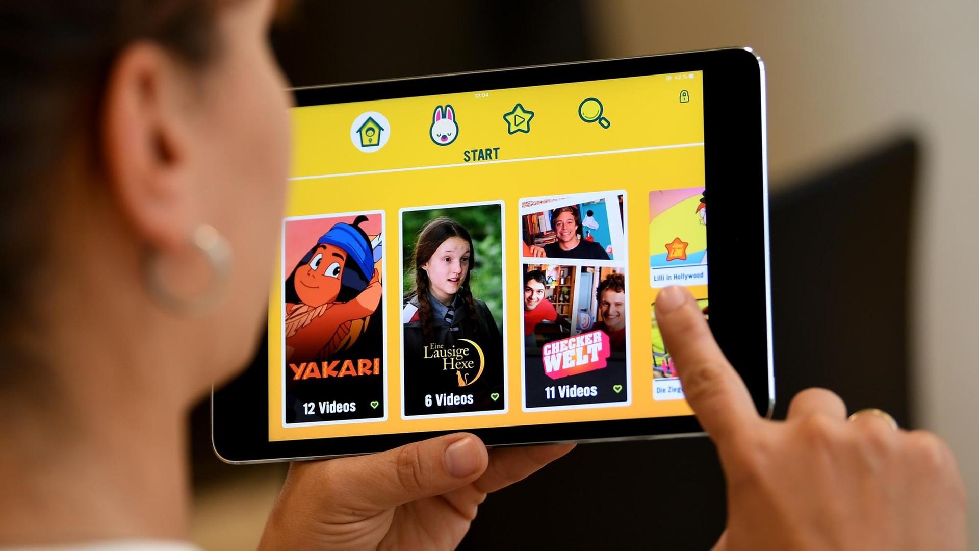 Eine junge Frau sieht sich die Mediathek-App "Kita-Player" an. Ab Herbst 2018 soll die App zum Download bereit stehen. Eine junge Frau sieht sich die Mediathek-App "Kita-Player" an. Ab Herbst 2018 soll die App zum Download bereit stehen.