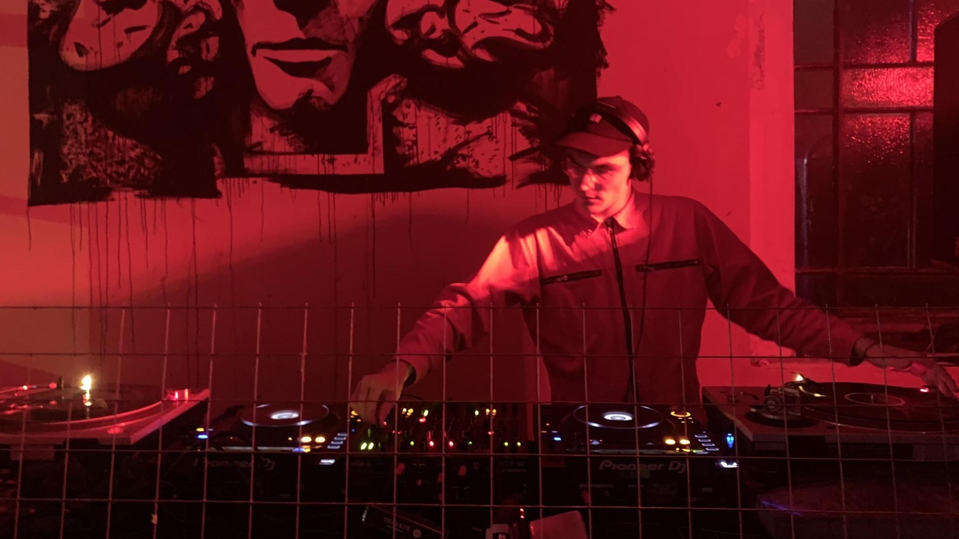 DJ Jakob Mandler im Technoclub in Mailand. Die Szene ist in rotes Licht getaucht. DJ Jakob Mandler im Technoclub in Mailand. Die Szene ist in rotes Licht getaucht.