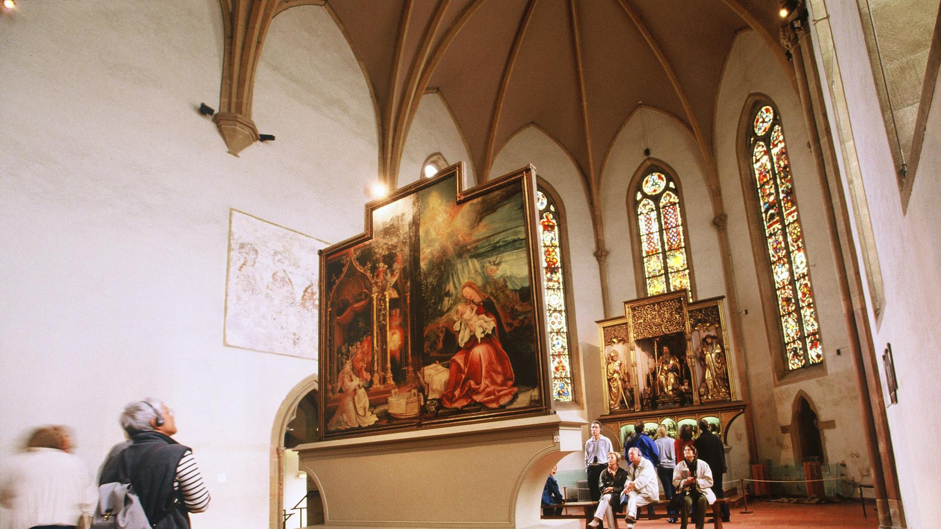 Blick auf Tafeln des "Isenheimer Altars", Gemälde der Kreuzigung Jesu im Altarraum einer Kirche