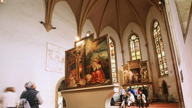 Blick auf Tafeln des "Isenheimer Altars", Gemälde der Kreuzigung Jesu im Altarraum einer Kirche
