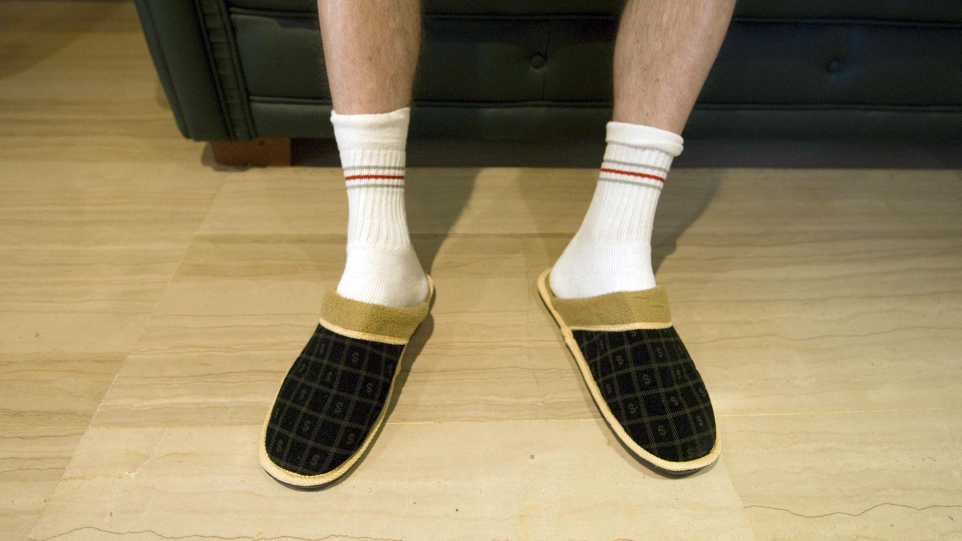 Entspannung auf dem Sofa in Sportsocken und Hausschuhen Entspannung auf dem Sofa in Sportsocken und Hausschuhen