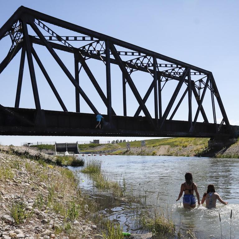 Kanada, Chestermere: Junge Leute kühlen sich in einem Bewässerungskanal ab. Die anhaltende Hitzewelle im Westen Kanadas hat für neue Höchsttemperaturen gesorgt und zu mehreren Todesfällen beigetragen.