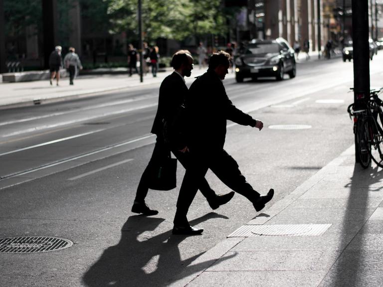 Zwei Männer überqueren eine Straße
