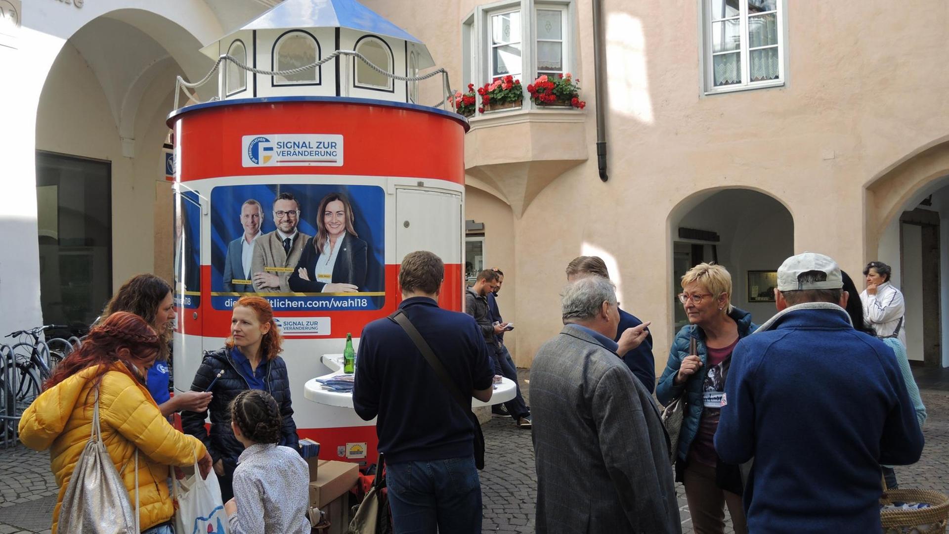 13.10.2018, Italien, Brixen: An einem Wahlkampfstand der rechtspopulistischen Partei Die Freiheitlichen werben Mitglieder der Partei um Stimmen. 13.10.2018, Italien, Brixen: An einem Wahlkampfstand der rechtspopulistischen Partei Die Freiheitlichen werben Mitglieder der Partei um Stimmen.