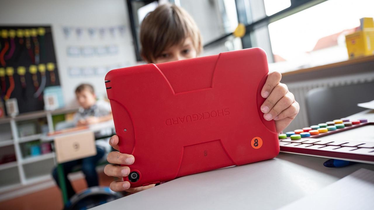 Ein junger Mensch arbeitet in einem Klassenzimmer in Baden-Württemberg mit einem Tablet. Ein junger Mensch arbeitet in einem Klassenzimmer in Baden-Württemberg mit einem Tablet.