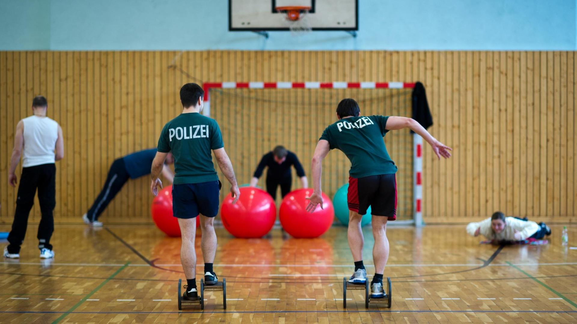 Polizeibeamte trainieren im Rahmen des Dienstsportes in einer Sporthalle. Polizeibeamte trainieren im Rahmen des Dienstsportes in einer Sporthalle.