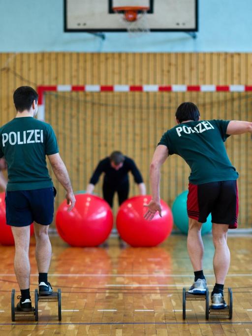 Polizeibeamte trainieren im Rahmen des Dienstsportes in einer Sporthalle.