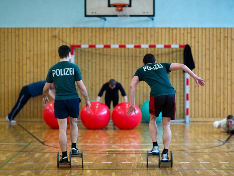 Polizeibeamte trainieren im Rahmen des Dienstsportes in einer Sporthalle.