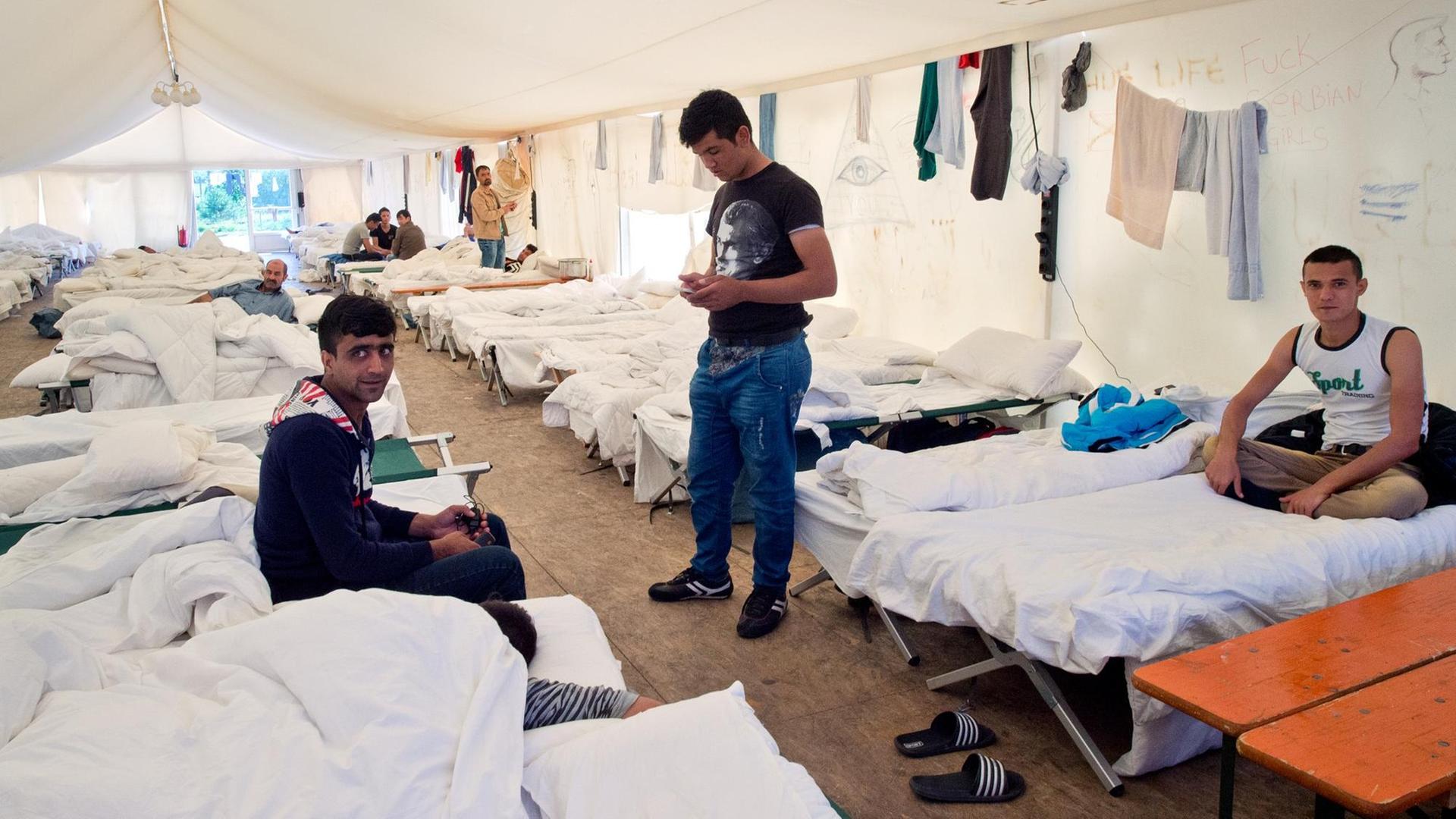 Flüchtlinge auf ihren Betten in einem Zelt der Hessischen Erstaufnahmeeinrichtung in Gießen. Flüchtlinge auf ihren Betten in einem Zelt der Hessischen Erstaufnahmeeinrichtung in Gießen.
