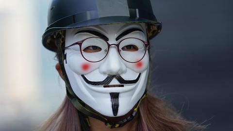 Eine maskierte Person, die an einer Demonstration in Hongkong teilnimmt.