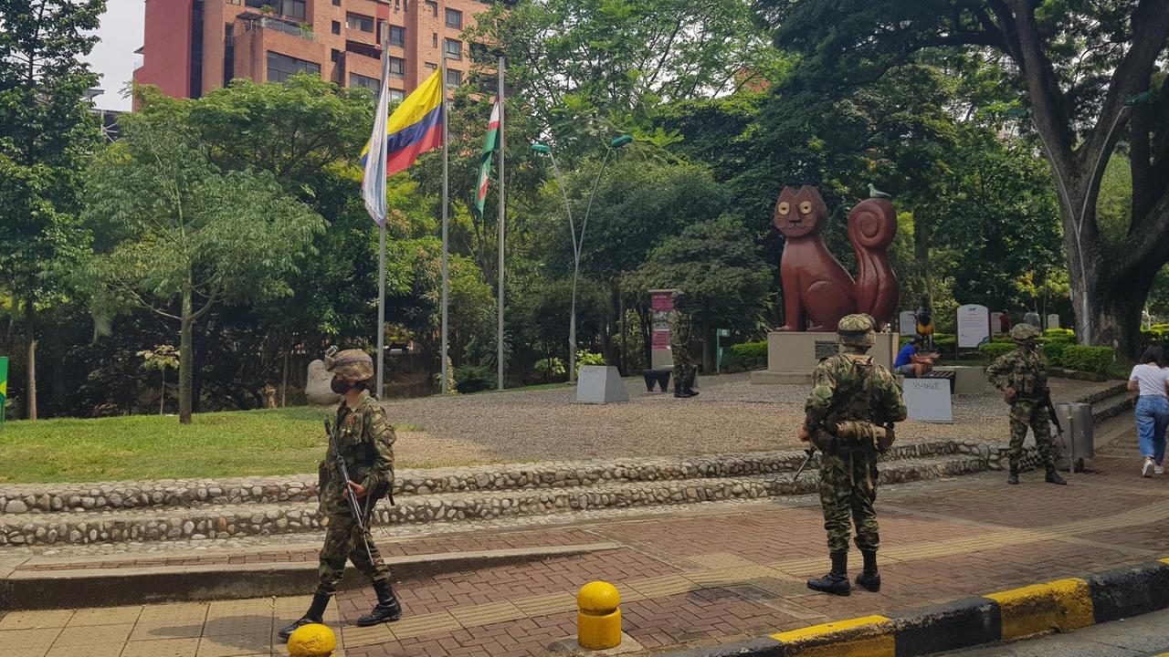 Bewaffnete Soldaten patrouillieren auf einem Platz.