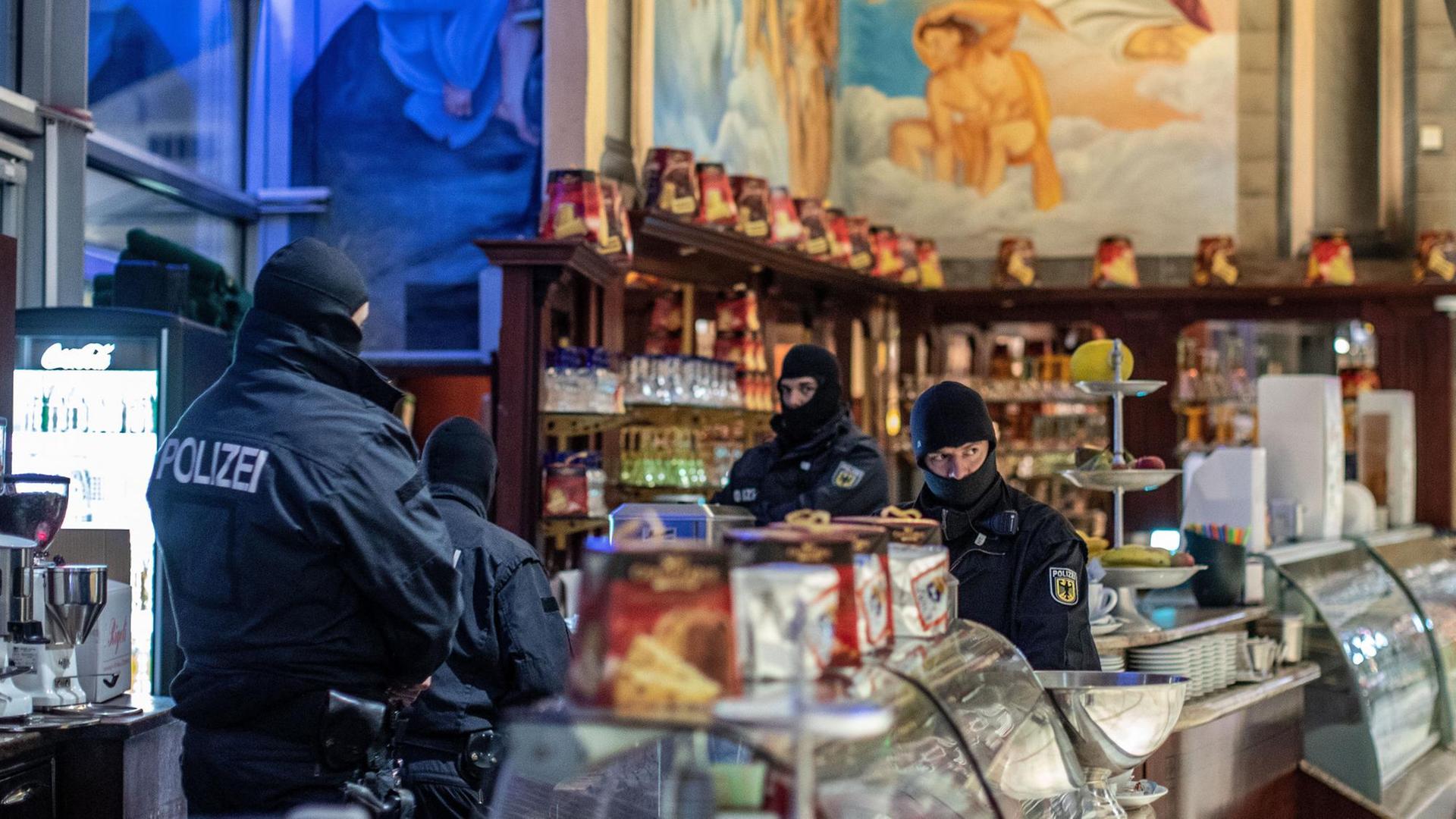 Vermummte Polizisten stehen in einem Eiscafé Vermummte Polizisten stehen in einem Eiscafé