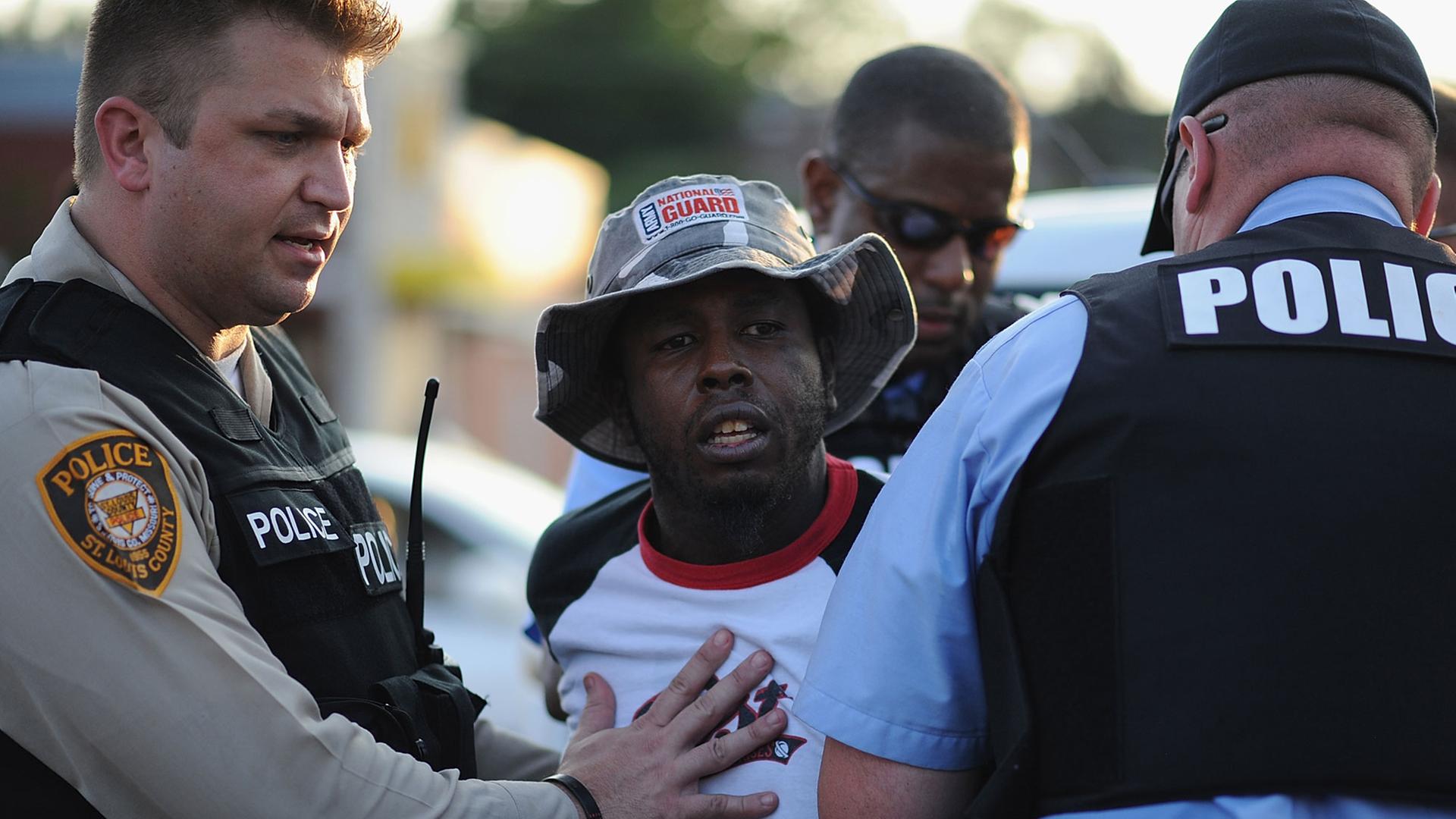 In der US-Kleinstadt Ferguson nimmt die die Polizei einen schwarzen Demonstranten fest. In der US-Kleinstadt Ferguson nimmt die die Polizei einen schwarzen Demonstranten fest.