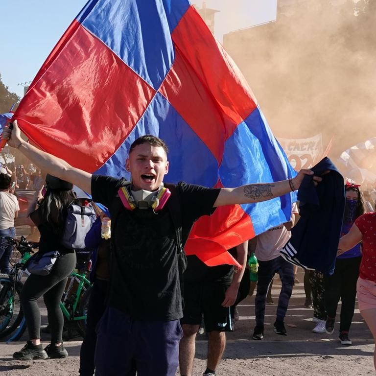 16.11.2019, Chile, Santiago de Chile: Jüngere Menschen mit Flaggen protestieren gegen die Regierung auf der Plaza Italia im Zentrum von Chile.