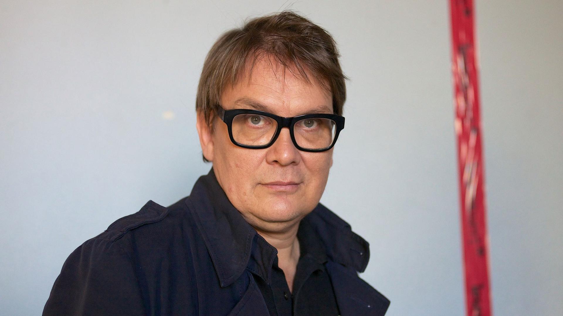 Der Musiker und Schriftsteller Sven Regener vor einer weißen Wand mit roten Streifen Der Musiker und Schriftsteller Sven Regener vor einer weißen Wand mit roten Streifen