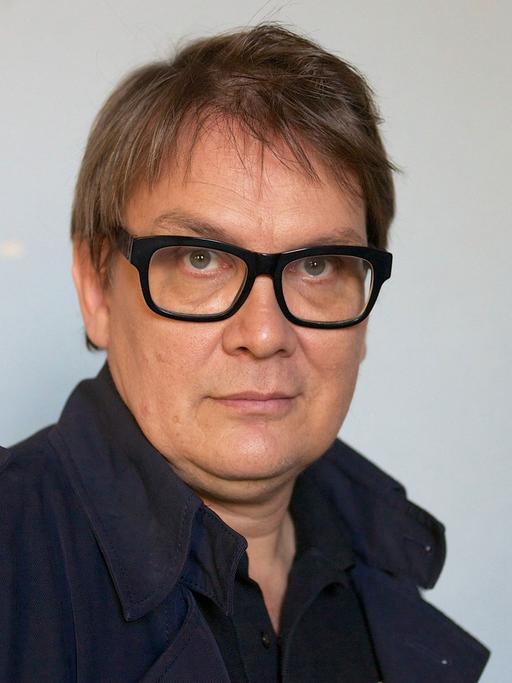 Der Musiker und Schriftsteller Sven Regener vor einer weißen Wand mit roten Streifen