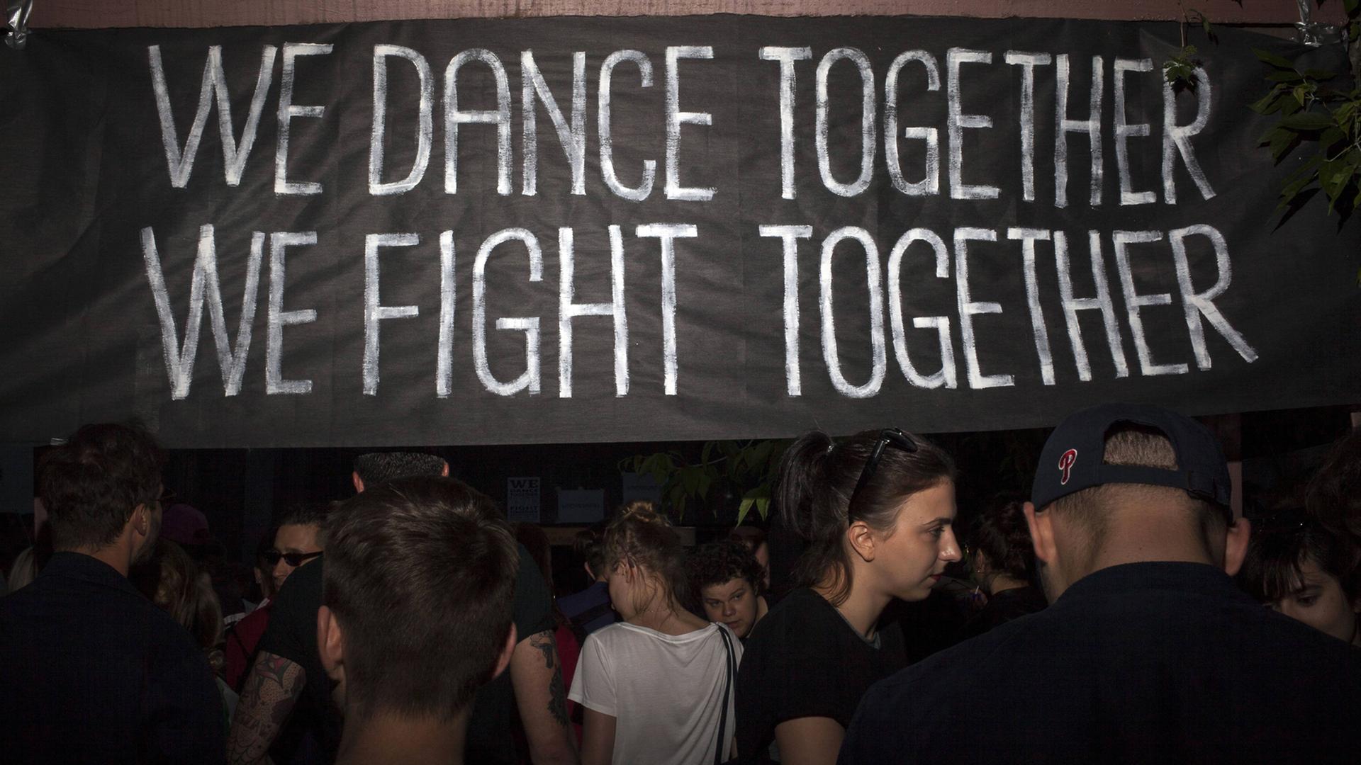 Demonstranten vor einem Banner mit der Aufschrift "We dance together, we fight together" während eines Protest in der Nähe der Botschaft Georgiens in Warschau Demonstranten vor einem Banner mit der Aufschrift "We dance together, we fight together" während eines Protest in der Nähe der Botschaft Georgiens in Warschau