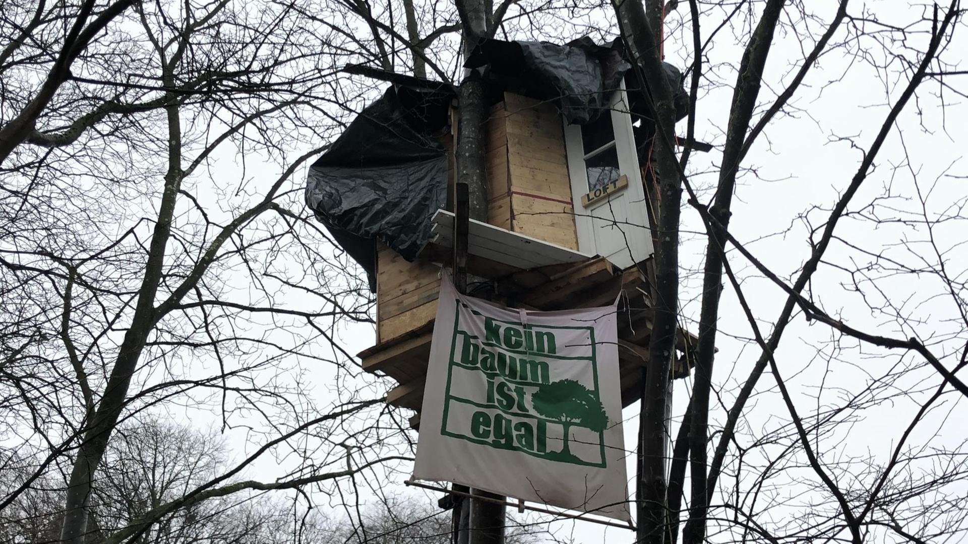 Ein Baumhaus mit einem Transparent mit der Aufschrift "Kein Baum ist egal" Ein Baumhaus mit einem Transparent mit der Aufschrift "Kein Baum ist egal"