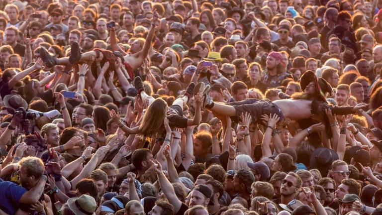 Eine grosse Menschenmenge feiert auf dem Musikfestival Wacken. Eine grosse Menschenmenge feiert auf dem Musikfestival Wacken.