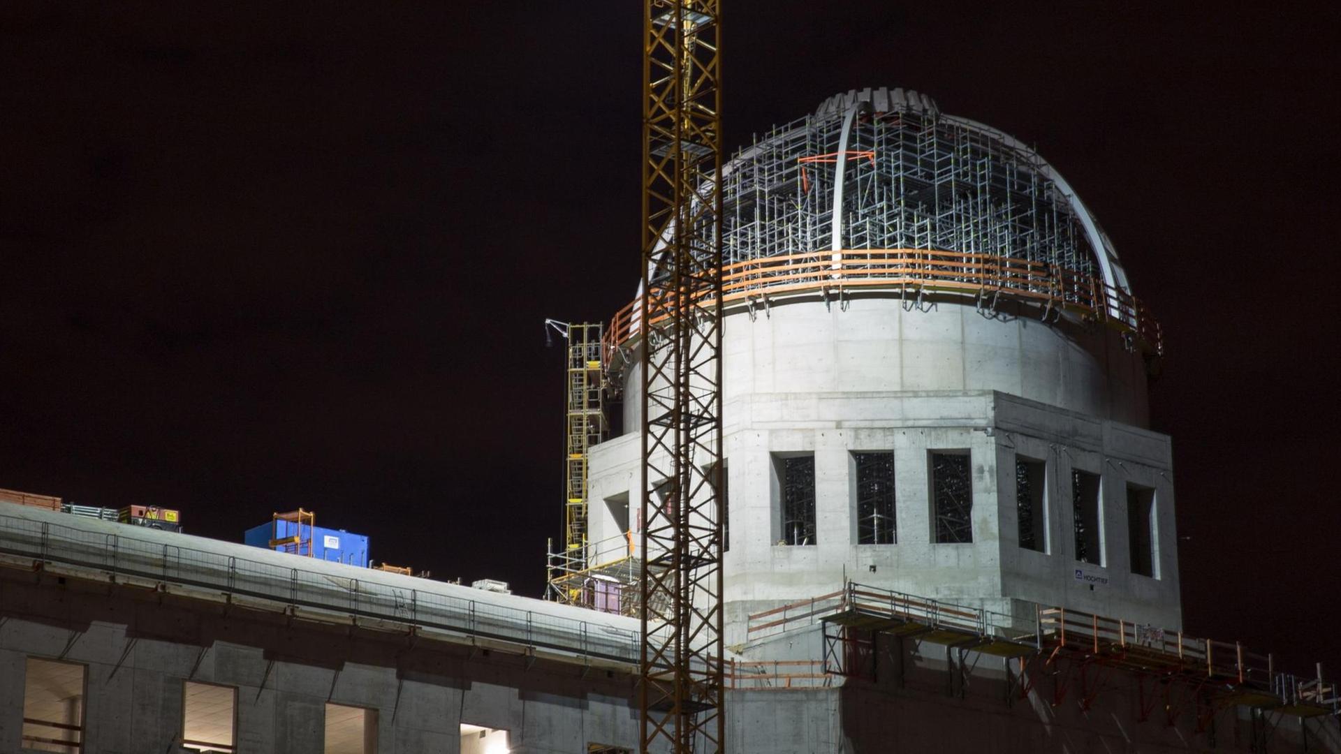 Die Kuppel des Rohbaus des Berliner Schlosses, das den Namen Humboldt-Forum trägt, in Berlin. Es ist Nacht, im Vordergrund ein Baukran. Die Kuppel des Rohbaus des Berliner Schlosses, das den Namen Humboldt-Forum trägt, in Berlin. Es ist Nacht, im Vordergrund ein Baukran.