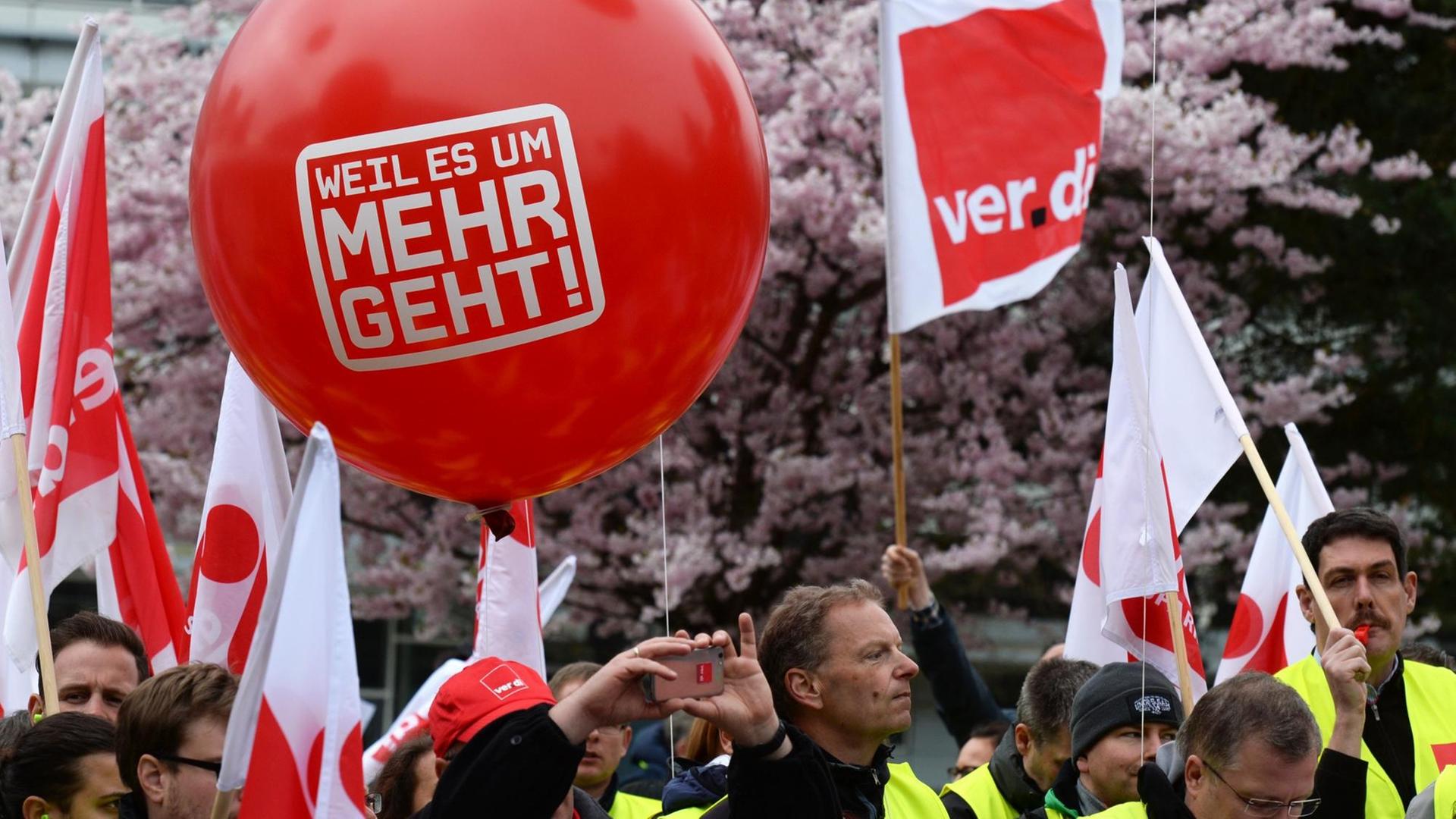 Demonstranten halten einen großen roten Luftballon mit dem Slogan "Weil es um mehr geht"
