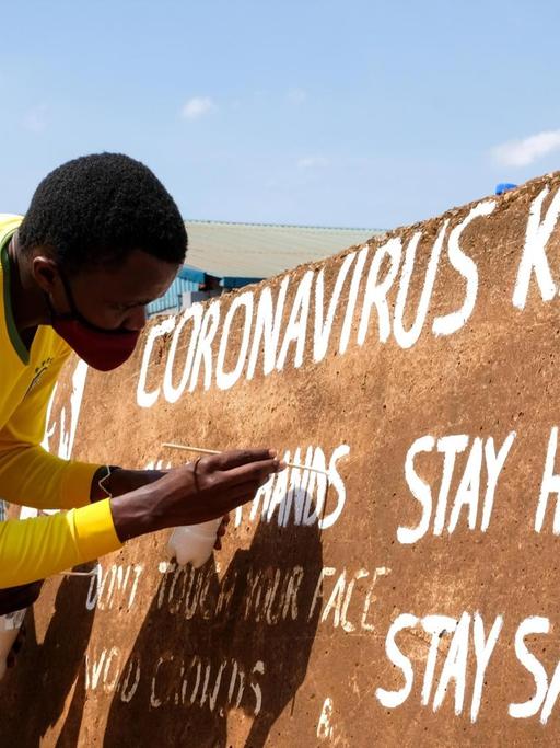(200929) -- KAMPALA, Sept. 29, 2020 (Xinhua) -- Visual artist Henry Jonathan Waguti works on a roadside wall as part of an anti-coronavirus awareness campaign in Kampala, capital of Uganda, Sept. 29, 2020. (Photo by Hajarah Nalwadda/Xinhua)