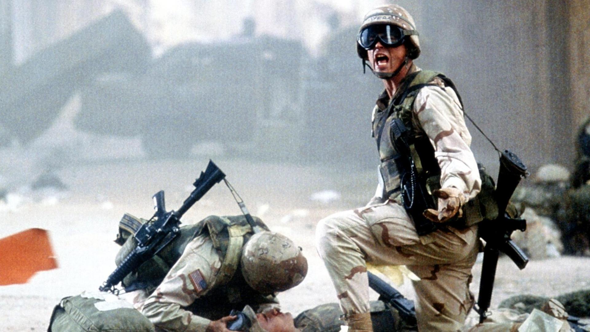 Der US-Elitesoldat Sergeant Matt Eversman (Josh Harnett, r.) kniet im Kinofilm "Black Hawk Down" während eines Gefechts in Somalias Hauptstadt Mogadischu bei einem verletzten Kameraden. Der US-Elitesoldat Sergeant Matt Eversman (Josh Harnett, r.) kniet im Kinofilm "Black Hawk Down" während eines Gefechts in Somalias Hauptstadt Mogadischu bei einem verletzten Kameraden.
