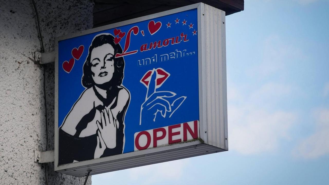 Ein Schild mit der Aufschrift "L'Amour und mehr - open" hängt an einer Hauswand Ein Schild mit der Aufschrift "L'Amour und mehr - open" hängt an einer Hauswand