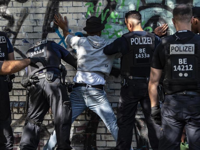 Polizeibeamte durchsuchen einen mutmaßlichen Drogendealer im Görlitzer Park.