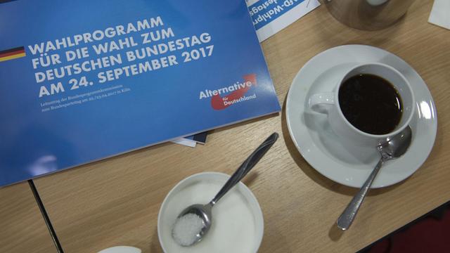 Die Broschüre "Wahlprogramm für die Wahl zum Deutschen Bundestag am 24. September 2017" liegt auf einem Tisch, daneben steht eine Tasse Kaffee