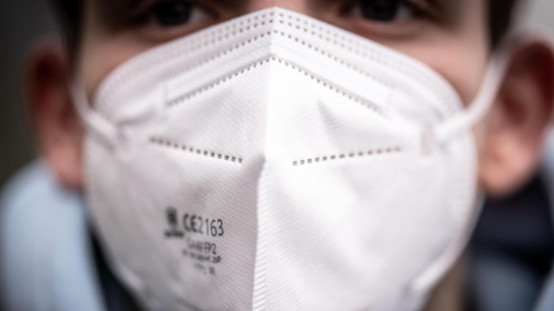 ILLUSTRATION - Ein junger Mann trägt eine FFP2-Maske. Zum Schutz vor dem Coronavirus sollen mehr Menschen aus Risikogruppen vom Bund finanzierte FFP2-Masken bekommen als zunächst vorgesehen. Nach einem Abgleich mit Versichertendaten der Krankenkassen sollen nun 34,1 Millionen statt 27 Millionen Bürger in diesen Tagen Gutscheine für zwölf FFP2-Masken zugesandt bekommen. ILLUSTRATION - Ein junger Mann trägt eine FFP2-Maske. Zum Schutz vor dem Coronavirus sollen mehr Menschen aus Risikogruppen vom Bund finanzierte FFP2-Masken bekommen als zunächst vorgesehen. Nach einem Abgleich mit Versichertendaten der Krankenkassen sollen nun 34,1 Millionen statt 27 Millionen Bürger in diesen Tagen Gutscheine für zwölf FFP2-Masken zugesandt bekommen.