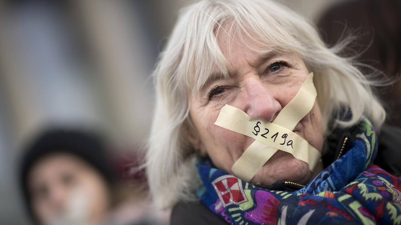 Eine Frau mit zugeklebtem Mund demonstriert gegen das Informationsverbot für Schwangerschaftsabbruch unter dem Motto "Weg mit dem Paragraph 219a StGb". Eine Frau mit zugeklebtem Mund demonstriert gegen das Informationsverbot für Schwangerschaftsabbruch unter dem Motto "Weg mit dem Paragraph 219a StGb".