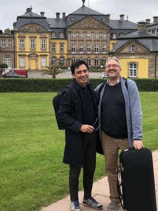 Die Brüder Marcello (links) und Enrico Gatti (rechts) gaben ihr Konzert bei den Barock-Festspielen im Residenzschloss Bad Arolsen. Sie stehen auf dem Weg vor dem Schloss mit ihren Instrumentenkästen