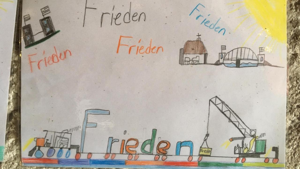 Ein Kinderbild mit der Brücke von Remagen und dem Wort "Frieden", mehrfach in bunter Schrift geschrieben Ein Kinderbild mit der Brücke von Remagen und dem Wort "Frieden", mehrfach in bunter Schrift geschrieben