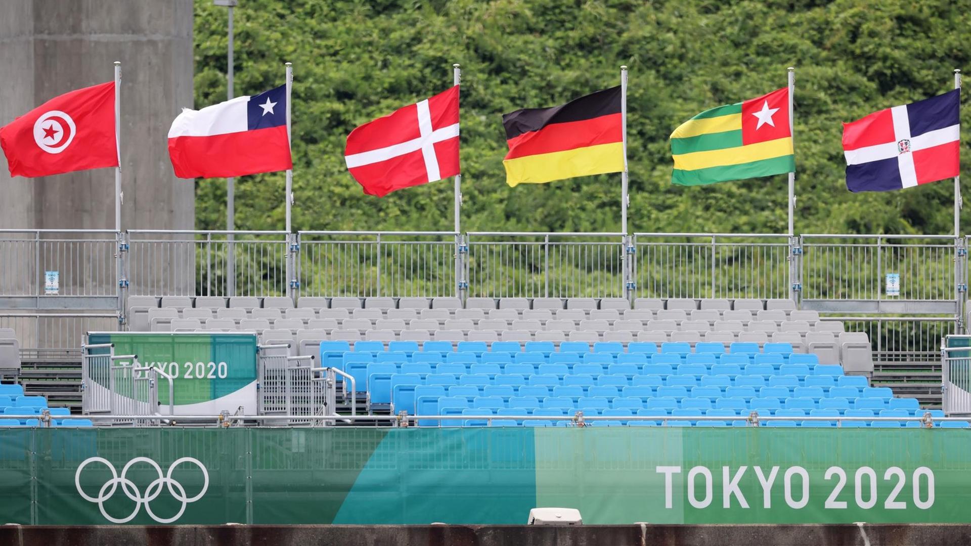 Fahnen verschiedener Nationen wehen über der leeren Tribüne bei den Olympischen Sommerspielen in Tokio. Fahnen verschiedener Nationen wehen über der leeren Tribüne bei den Olympischen Sommerspielen in Tokio.
