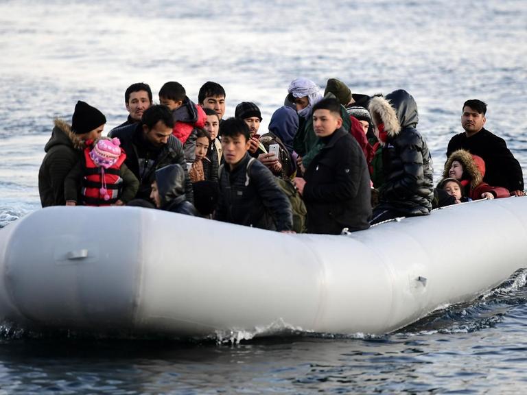 Migranten fahren in einem Boot, kurz bevor sie ein Dorf auf der griechischen Insel Lesbos erreichen über die Ägäis von der Türkei aus kommend.
