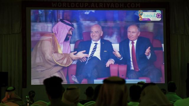 Auf einer Leinwand sind Mohammed Bin Salman, Gianni Infantino und Wladimir Putin während des Eröffnungsspiels der Fußball-WM 2018 im Stadion zu sehen
